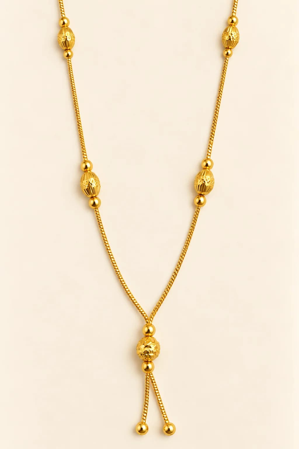 Meera gold-tone mangalsutra with textured oval gold beads and a diamond-cut ball lariat drop
